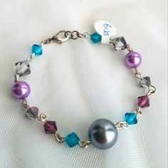 A Hand Crafted Bracelet Made With Swarovski Elements And Faux Pearls. The Crystals Are In A Beautiful Teal, Purple And Metallic Silver Shade, While The Faux Pearls Are In A Grey And Mauve Shade. Lobster Closure. Wear It Alone, Or Layer With Your Watch And Other Bracelets. Brand New With Tags. Smoke Free And Pet Free Home. Adjustable Elegant Purple Crystal Bracelet, Elegant Purple Crystal Bracelet For Party, Elegant Purple Beaded Crystal Bracelet, Pet Jewelry, Faux Pearl Bracelet, Handmade Pet, Handcrafted Bracelets, Animal Jewelry, Purple Grey