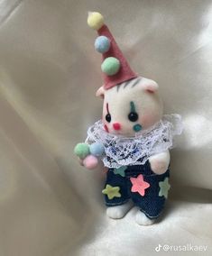 a small toy cat with a clown hat on it's head