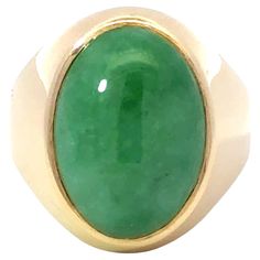 Item Specifications: Metal: 14k Yellow Gold Style: Statement Ring Ring Size: 8.75 (resizing available for a fee) Total Weight: 13.2 Grams Gemstone Specifications: Center Gemstone: Jadeite Jade Shape: Oval Color: Green Cut: Cabochon ​ ​Jade Measurements: ~18.5 mm x 13.3 mm 5.8 mm Jade Carat Weight: ~13 carats Condition: Vintage, Excellent ​ ​Stamped: "14k" 14k Gold Oval Cabochon Gemstone Signet Ring, Oval Cabochon Signet Ring For Formal Events, Oval Cabochon Signet Ring For Formal Occasions, Luxury Yellow Gold Emerald Ring With Oval Cabochon, Oval Gemstone Dome Ring In Yellow Gold, Elegant Untreated Oval Gemstones, Untreated Oval Elegant Gemstones, Oval Cabochon Signet Ring In Fine Jewelry Style, Oval Polished Emerald Ring In 14k Gold