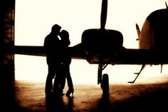 two people standing in front of an airplane