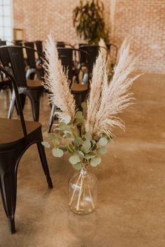 a vase filled with flowers sitting on top of a table next to a black chair