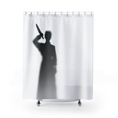 a shower curtain with a silhouette of a man holding a knife in his hand and the shadow of a person behind it