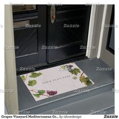 a door mat with the eiffel tower and holly wreaths on it in front of an entrance