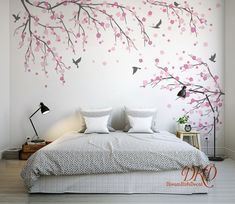 a bedroom with white walls and pink flowers painted on the wall above the headboard