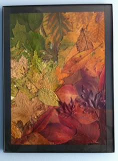 a painting with leaves on it hanging on the wall