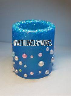 a blue candle holder with pearls on it and the words, with love clay works