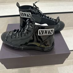 Brand New Valentino High Top Sneakers. It Can Be Unisex, It Comes With The Original Box Dust Bag. Just Like You’ll Buy From The Store. Designer High-top Sneakers With Logo Detail, Luxury Black High-top Sneakers With Logo, Designer High-top Sneakers With Logo, Casual Patent Leather High-top Sneakers With Round Toe, Designer Black High-top Sneakers With Logo Print, Casual Patent Leather High-top Lace-up Sneakers, Luxury High-top Custom Sneakers With Logo, Designer High-top Sneakers With Vulcanized Sole, Designer Patent Leather Lace-up Sneakers