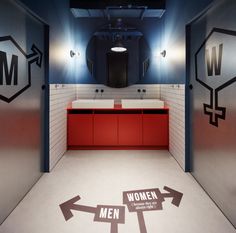 a bathroom with men and women signs painted on the floor in front of two sinks