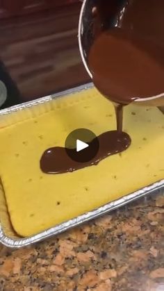 someone pouring chocolate into a pan on top of a counter