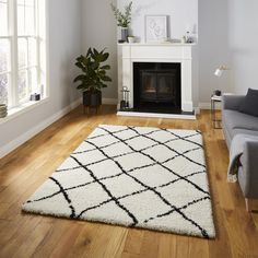 a living room filled with furniture and a fire place next to a couch on top of a hard wood floor