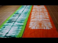 two orange and green striped rugs sitting on top of a wooden floor next to each other