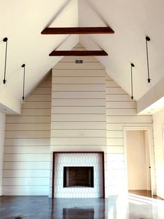 an empty living room with a fireplace and vaulted ceiling