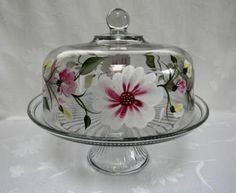 a glass cake dish with flowers painted on it