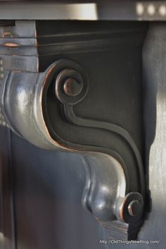 a close up view of an ornate metal handle on a wooden door with black paint