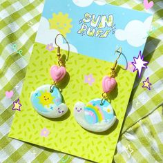 the sun and moon earrings are sitting on top of a green tablecloth with stars