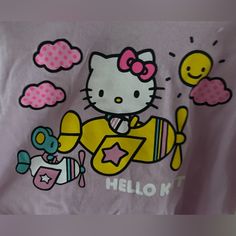 a hello kitty t - shirt with an airplane and other cartoon characters on the front