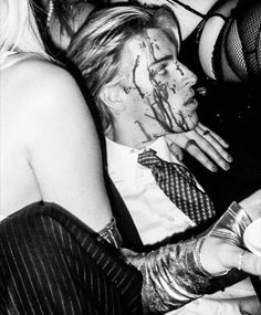 black and white photograph of people dressed up as zombies eating food at a halloween party