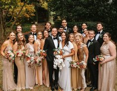 a group of people standing next to each other in formal wear and holding bouquets