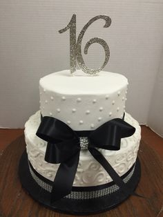 a close up of a cake on a table with a ribbon and number 16 on it