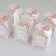 four small boxes with pink flowers and butterflies on them, one is open to show the inside