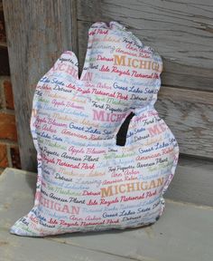 a stuffed animal sitting on top of a wooden bench next to a building with words written all over it