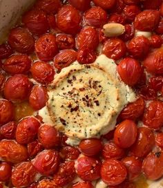 tomatoes and cheese are in a pot with some sauce on the top, ready to be cooked