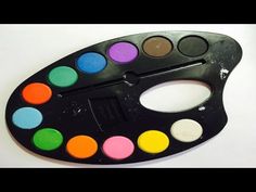 a black paint palette with multicolored eyeshades sitting on a white surface