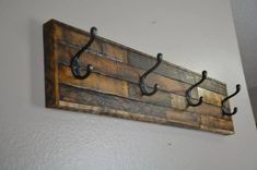 a coat rack made out of wood and metal hooks