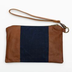 Stylish and durable, this Eastport Clutch is made to accompany you on all of your travels. Perfect for those on the go! Attach the Eastport Clutch to the inside of the Saco River tote Bag or the Fore Street Tote Bag (sold separately) to make a stylish set. Due to the nature of the leather, variations in color may occur. Made in a solar-powered workshop in Maine. Includes detachable leather wrist strap with a bronze lobster clasp built-in leather hand clutch strap zip-top closure Materials waxed