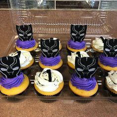 cupcakes with purple frosting and black masks on them in a plastic container