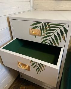 two drawers with palm leaves painted on the front and bottom, one drawer is open