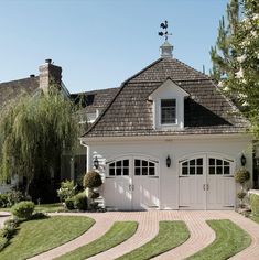 a white house with two garages in the front yard