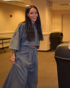 a woman standing next to a trash can in an empty room with chairs and tables