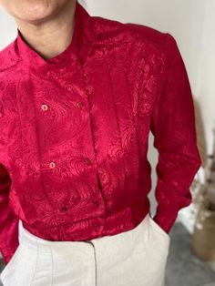 A stunning piece, loaded with 1980s charm, this medium red coloured vintage blouse is beautifully made and a total joy to wear. Made in the United Kingdom, it was designed by St Michael and is fully of vintage detailing, from the pleats to the subtle but very effective paisley print. Condition: excellent vintage condition Measurements: contrary to the UK14 label, today the measurements tally with: UK 12 EU 40 US 10 Bust: 36 inches / 91 cm Length: 26 inches / 66 cm Fitted Red Vintage Blouse, Classic Red Tops For Party, Classic Red Top For Party, Classic Red Party Tops, Classic Red Party Top, Red Vintage Formal Top, Retro Red Formal Tops, Red Retro Formal Tops, Red Vintage Blouse For Party