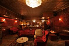 a room filled with lots of red couches and chairs