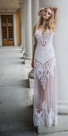 a beautiful blonde woman in a white dress leaning against a pillar with her hand on her head