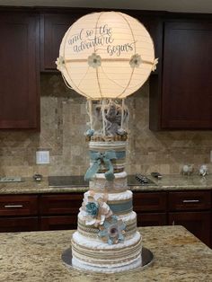 a wedding cake sitting on top of a kitchen counter next to a light up globe