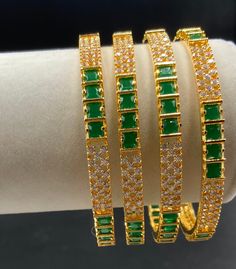 Set of 4 emerald & CZ stones bangles One gram gold jewelry  Handmade jewelry  Silver plated jewelry  Size: 2.6 🌸 C O N N E C T . W I T H . U S  🌸 Please share/ tag us with your photos adorning our jewelry on our social media pages : https://www.pinterest.com/globusfashions https://www.instagram.com/globusfashions https://www.facebook.com/globusfashions 🌸 C A R E . T I P S  🌸 We don't want your special moments to fade. To maintain the quality of your jewelry, please : - Do not wear it to the pool, spa, or the beach. - Remove when sleeping, exercising, or doing other physically strenuous activities. - Avoid contact with perfumes, body oils, and other chemicals, including household cleaners. - Do not use chemical jewelry cleaners. - Gently polish with a soft, lint-free cloth after every u Green Cubic Zirconia Bangle, Green Gold-plated Bangle, Green Cubic Zirconia Bangle Jewelry, Green Bangle For Celebration, Green Bracelet Jewelry For Celebration, Green Gold Plated Bracelets For Weddings, Unique Gold Jewelry Designs, Womens Bangles, Handmade Gold Jewellery