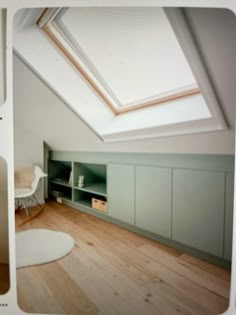 an attic bedroom with skylights and storage cabinets on the wall, along with hardwood flooring