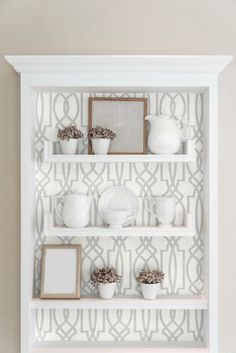 a white shelf filled with plates and bowls