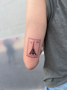 a person with a small tattoo on their arm that has the eiffel tower in it