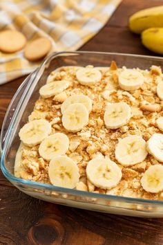 homemade southern banana pudding in a glass baking dish on a wooden table with bananas around it