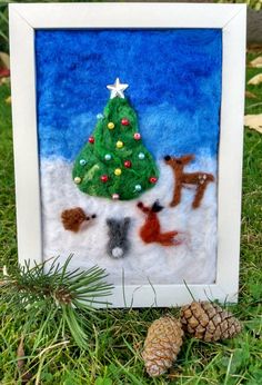 a christmas tree with animals and a pine cone on the ground