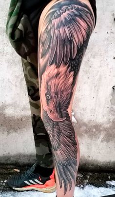 a person with a tattoo on their leg and an eagle in the middle of it