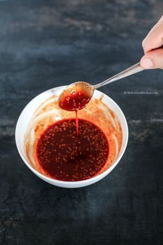 a person is spooning sauce into a bowl