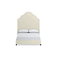 a white bed with two pillows on top of it