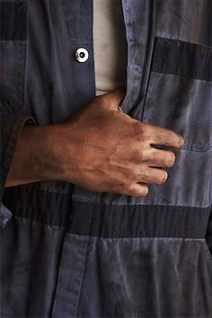 a close up of a person's hand wearing a black and blue shirt jacket