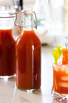 there are two glass bottles with sauces on the table next to eachother