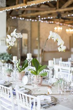 the table is set with white flowers and place settings for guests to sit down at