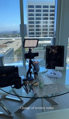 a camera set up on a glass table in front of a window